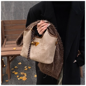 Détail du cabas en toile beige avec garniture en cuir marron et logo dans un décor d'automne