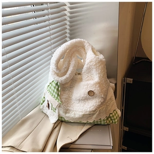 Detail der weißen Lammwoll-Tasche mit grünem Karomuster und Vintage-Holzknopf-Akzent