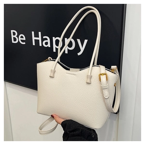 Détail du sac à main en cuir blanc texturé avec boucle dorée et bandoulière fine