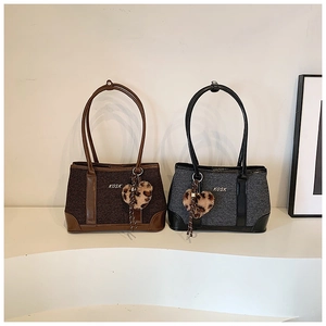 Detail of retro tote bags in coffee and grey tweed with heart-shaped leopard plush charm