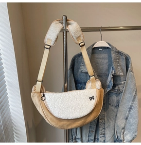 Detail of plush crescent bag with shearling trim and stylish black bow accent