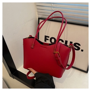 Détail du sac cabas rouge en cuir grainé avec boucle en métal doré ajustable