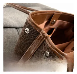 Detail of dark brown wool tote bag with leather trim and silver metal button snap