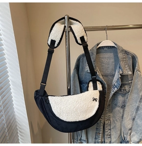 Detail of plush half-moon bag featuring black nylon, white faux fur, and bow ornament