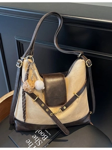 Chic beige canvas tote bag with brown leather trim and creative baseball charm detail