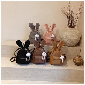 Mini sacs à dos avec oreilles de lapin en cinq couleurs sur des marches en pierre