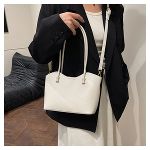 Détail d'un sac cabas blanc en cuir grainé avec bordure ondulée et finitions dorées chic