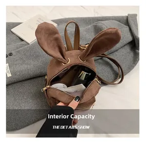 Détail intérieur d'un sac à dos en daim marron avec grande capacité pour maquillage et soins