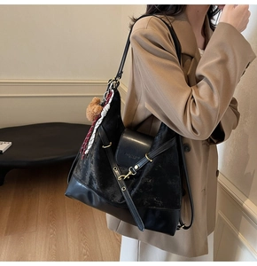 Model wearing a black tote bag with velvet patchwork, teddy charm, and checkered scarf