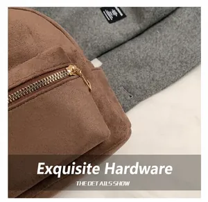 Détail montrant la texture en daim marron et la fermeture éclair dorée de ce sac chic