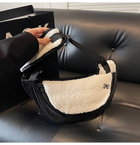 Detail view of crescent plush bag with black and white fleece and a bow ornament
