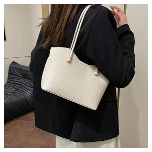 Détail du sac cabas blanc cassé avec texture grain litchi et longues anses rondes