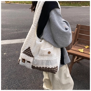 Detailaufnahme der Sherpa-Tasche mit Karomuster und kleiner Tasche im Hausdesign