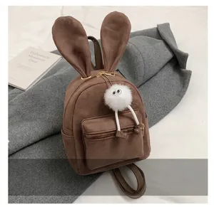 Détail du mini sac à dos en daim marron avec oreilles de lapin et charme en peluche