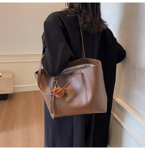 Sac fourre-tout en cuir marron avec un pendentif ours en peluche et fines bandoulières