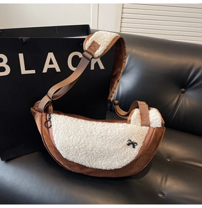Detail of plush half-moon crossbody bag with fleece panels and black ribbon bow