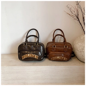 Detail of vintage bowling bags in chocolate and caramel with plush HOLIDAY embroidery