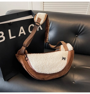 Detail of crossbody bag featuring brown suede, white sherpa fabric and bow decoration