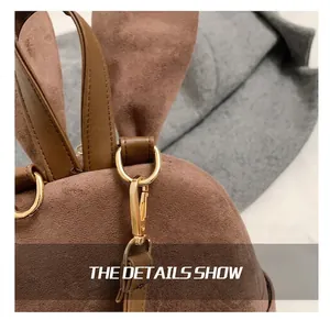 Gros plan sur les crochets dorés et la texture daim marron d'un sac à dos oreilles de lapin