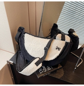 Detail of crescent plush bag with faux fur trim, black bow, and adjustable strap