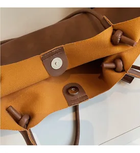 Détail du sac cabas montrant le fermoir magnétique argenté et les nœuds en cuir