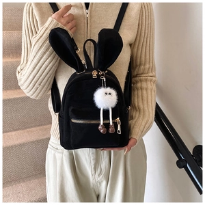 Détail du mini sac à dos en peluche noire avec oreilles de lapin et pendentif mignon