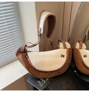 Detail of half-moon plush crossbody bag with bow hardware and faux shearling trim