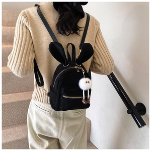 Détail du mini sac à dos noir avec oreilles de lapin et charm monstre en peluche