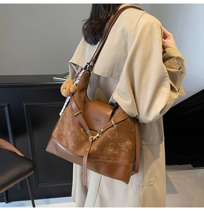 Brown faux suede tote bag with scarf detail and bear charm shown from a side view