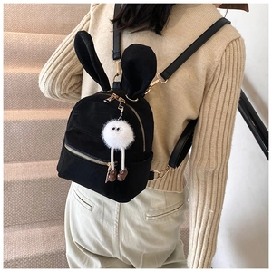Détail d'un mini sac à dos en velours noir avec oreilles de lapin et charme en peluche