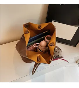 Vue de dessus du sac seau marron montrant le grand intérieur pour tablette et parapluie