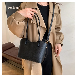 Détail du sac cabas en cuir noir grainé avec ses fines doubles anses élégantes