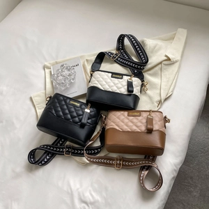 Flat lay of quilted leather crossbody bags in black, bicolor, and brown with woven straps