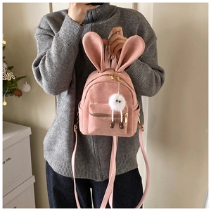 Détail d'un mini sac à dos rose en daim avec oreilles de lapin et pendentif peluche