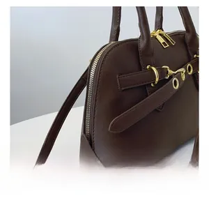 Detailed shot of dark brown retro shell bag with refined texture and gold hardware accents