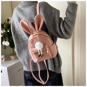 Détail d'un mini sac à dos rose avec oreilles de lapin et texture douce en suédine