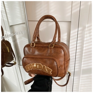 Detailed macro view of brown vintage leather bag with beige plush HOLIDAY letter patches