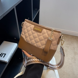 Detailed close-up of quilted beige leather texture and gold chain on crossbody bag