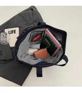 Spacious interior of denim tote bag showing tablet, phone and wallet storage