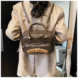 Model showing dark brown vintage backpack with plush letter patches in a lifestyle setting