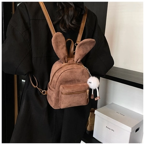 Gros plan du mini sac à dos en daim marron avec oreilles de lapin et pompon en fourrure