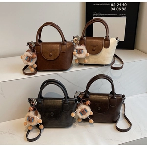 Detail view of retro crossbody bucket bags in four colors with plush sheep pendants