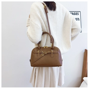Brown vintage shell bag shown with adjustable strap in a daily outfit context