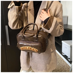 Detail of vintage brown leather handbag with plush holiday patch on a model outfit