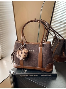 Brown vintage canvas tote bag with leather handles and leopard heart charm