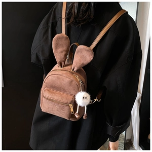 Vue détaillée du mini sac à dos en daim marron avec oreilles de lapin et pendentif peluche