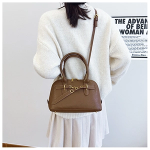 Detail of vintage brown shell bag with matte texture and gold hardware rings