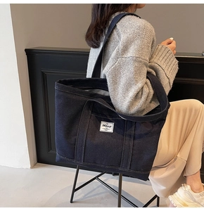 Detail of a large dark blue denim tote bag with Hbbag label and stripe lining detail