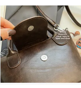 Detail of strong magnetic snap closure on vintage dark brown leather handbag with handle