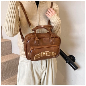 Brown faux leather vintage backpack showing plush HOLIDAY embroidery and top handle